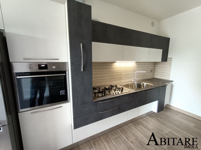 Cucina chiara con forno in colonna e piano cottura